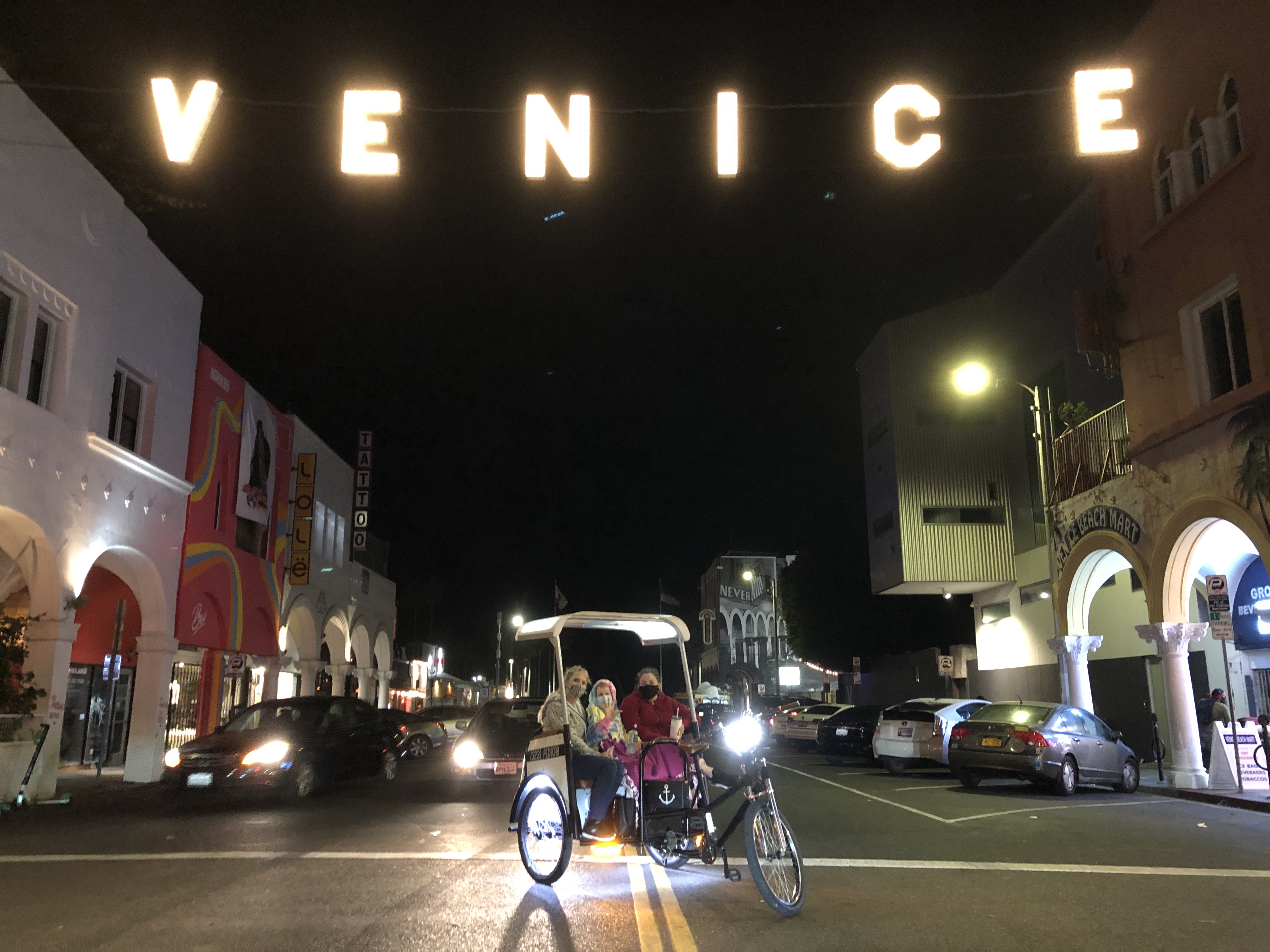 Michelle posing under the lit Venice sign.