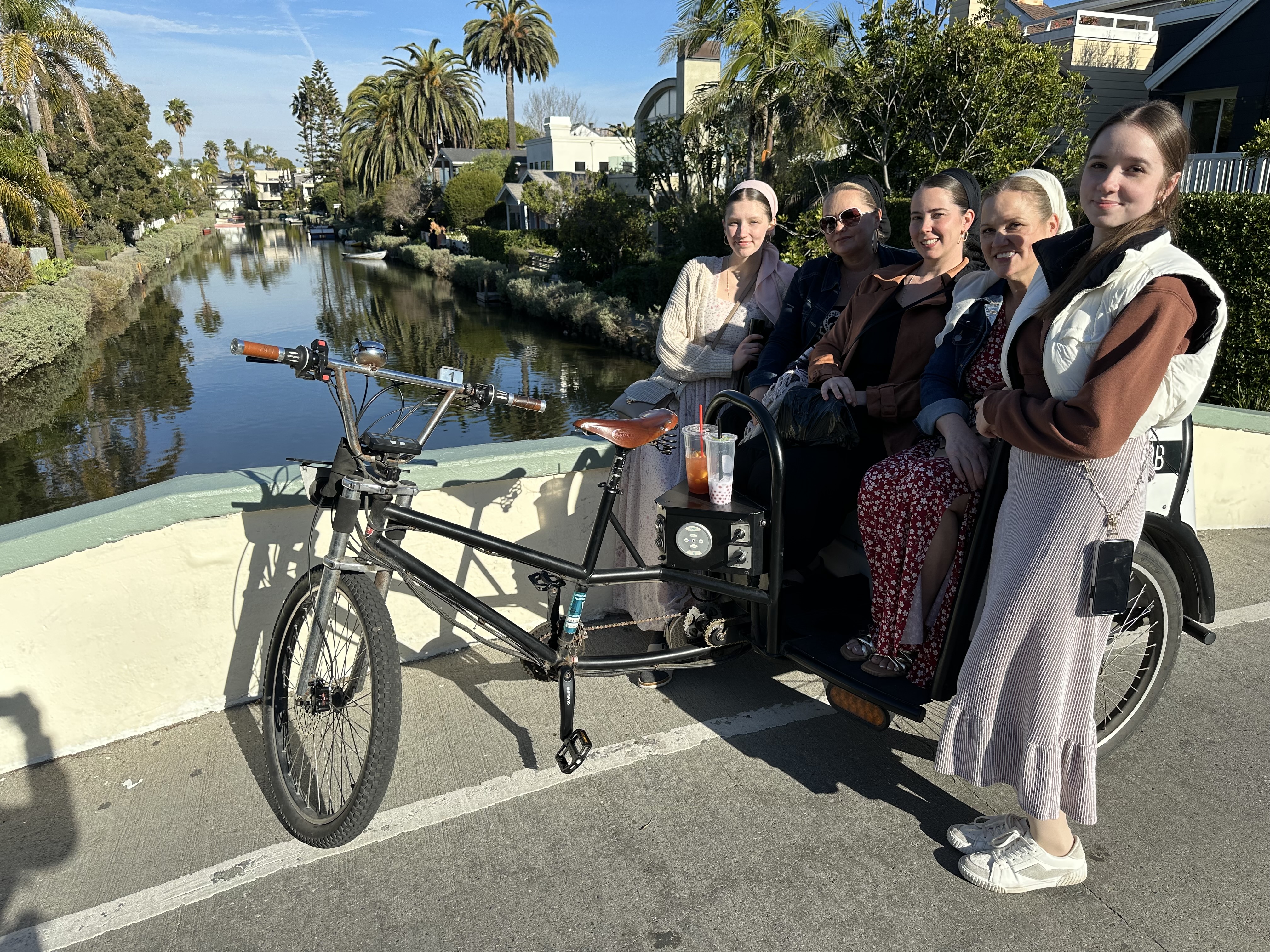 A Beach Buggy pedicab parked on a bridge over the Venice Canals.